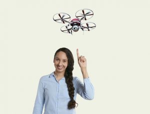 Creative woman pointing to a drone above her